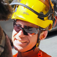 Close-up of Paul Duncan, the lead arborist and owner of Garibaldi Tree. Paul is smiling and wearing a yellow arborist helmet.